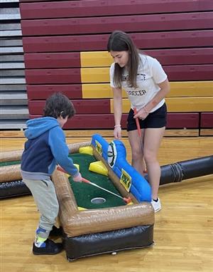 Child and teen playing mini golf